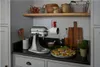A KitchenAid stand mixer with a food grinder attachment on a kitchen counter, preparing vegetables for a salad. Produktbild-Vorschau