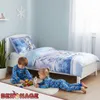 Two children in pajamas playing on the floor in a bedroom with a Frozen-themed bed. Produktbild-Vorschau