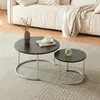 A living room setting with a sofa and a rug, featuring two round coffee tables. Produktbild-Vorschau