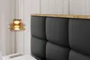 A close-up view of a bed's upholstered headboard with a wooden trim, and a hanging lamp. Produktbild-Vorschau