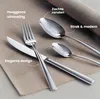 A set of cutlery, including a knife, fork, and two spoons, arranged on a textured fabric surface. Náhled obrázku produktu