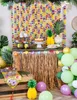 A festive Hawaiian-themed party setup with a table decorated with a grass skirt, colorful flower garlands, balloons, and a cake. Podgląd zdjęcia produktu