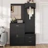 A black entryway cabinet with a mirror, coat hooks, and a bench is shown in a room with a gray sofa and a white door. Podgląd zdjęcia produktu