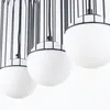 A close-up studio shot of three pendant lights with black cages and white spherical globes. Podgląd zdjęcia produktu