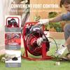 A person is using a red pipe cleaning machine outdoors on grass. Podgląd zdjęcia produktu