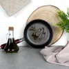 A cast iron pan with oil, a bottle of olive oil, and a kitchen pot holder on a gray surface. Náhľad obrázku produktu