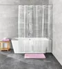 A clean and modern bathroom setting with a bathtub, shower curtain, and accessories. Produktbild-Vorschau