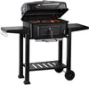 A black charcoal grill with the lid open, showing food on the grates, set against a white background. Produktbild-Vorschau