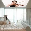 A person in a hooded outfit sits on a bed, looking at a projector that is projecting an image of a woman playing a violin onto the ceiling. Produktbild-Vorschau
