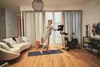 Frau trainiert im Wohnzimmer mit dem Horizon AtCycle und macht Yoga-Übungen Produktbild-Vorschau