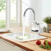 A kitchen sink with a faucet dispensing hot water onto food, with vegetables and tomatoes on the countertop. Produktbild-Vorschau