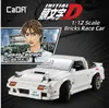 A promotional image for a white CaDA Mazda FC3S RX-7 brick race car model, featuring an anime character and product details. Produktbild-Vorschau