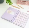 An open notebook with a purple cover and a patterned interior page, placed on a white surface with some stationery items in the background. Náhľad obrázku produktu
