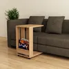 A wooden side table with magazines is placed next to a sofa. Produktbild-Vorschau