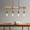 A wooden beam pendant light with four Edison bulbs hangs above a wooden dining table. Anteprima dell’immagine prodotto