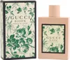 Gucci Bloom Acqua di Fiori Eau de Toilette in rosa Flakon mit floralem Etikett, daneben passende grün-beige Box mit Blumen- und Schmetterlingsmuster. Produktbild-Vorschau