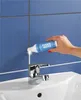 A hand applying grout whitener to tile grout above a sink faucet. Produktbild-Vorschau