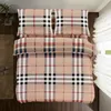 A neatly made bed with plaid bedding. Náhľad obrázku produktu