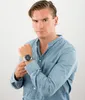 A man wearing a blue shirt and a watch. Produktbild-Vorschau