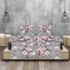 A bed with a floral print duvet and pillows, set against a textured gray wall with pendant lights. Produktbild-Vorschau