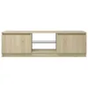 A front view of a light brown TV stand with a glass shelf in the middle. Náhled obrázku produktu