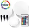 Three white spherical lights and a remote control are displayed on a white background, along with three black ground stakes. A circular graphic with a rainbow gradient and German text is in the top left corner. Anteprima dell’immagine prodotto