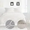 A bed with white bedding, with icons indicating washing instructions and a close-up of a zipper. Produktbild-Vorschau