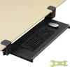 A black keyboard tray with a keyboard and mouse attached, clamped to the underside of a wooden desk. Produktbild-Vorschau