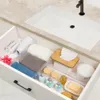 An open bathroom drawer filled with toiletries and towels. Produktbild-Vorschau