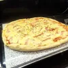 A pizza on a stone slab, likely in a kitchen setting. Podgląd zdjęcia produktu
