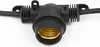 A close-up shot of a black outdoor string light socket with a gold-colored bulb receptacle, set against a white background. Produktbild-Vorschau