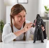A young girl is playing with a Darth Vader action figure. Anteprima dell’immagine prodotto