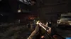 First-person perspective of a video game scene, showing a character holding a rifle with muzzle flash, in a dark, abandoned industrial setting with a truck in the background. Produktbild-Vorschau