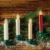 Four LED Christmas tree candles with green clips are arranged on a wooden surface, nestled among pine branches and artificial snow. Produktbild-Vorschau