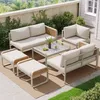 An outdoor patio set arranged on a rug, with greenery and a building in the background. Voir les images du produit