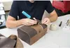 A person is using a glue gun on a decorative box. Produktbild-Vorschau
