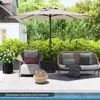 An outdoor patio scene with a large umbrella providing shade over patio furniture and a small table. Produktbild-Vorschau