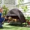 A woman interacting with a dog on an elevated outdoor pet bed with a canopy. Anteprima dell’immagine prodotto