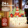 A wooden advent calendar with a Christmas train decoration, set against a blurred background of a Christmas tree and window. Produktbild-Vorschau