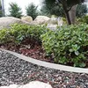 A garden bed with a metal edging separating gravel from plants. Produktbild-Vorschau