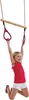 A young girl is hanging from a wooden trapeze bar with pink rings. Anteprima dell’immagine prodotto