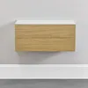 A wall-mounted shelf with two drawers against a light gray wall, with white baseboard trim below. Náhľad obrázku produktu