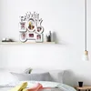 A multi-photo frame collage displaying the word "FAMILY" is mounted on a white wall above a bed with pillows and blankets. Produktbild-Vorschau