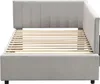 A side view of a gray upholstered bed frame with a wooden slat support system. Produktbild-Vorschau