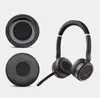 A pair of black headphones with orange accents and two replacement ear pads are displayed against a light gray background. Produktbild-Vorschau