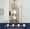 A hallway with several black ceiling lights, a rug on the floor, and a bench and mirror on the left wall. The bottom of the image shows a graphic with different lighting modes. Anteprima dell’immagine prodotto
