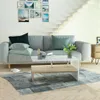 A living room scene with a couch, coffee table, and wall art. Podgląd zdjęcia produktu