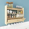 A wooden kitchen shelf mounted on a light blue wall, filled with various kitchen items. Náhled obrázku produktu