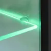A close-up view of a glass shelf with green LED lighting. Anteprima dell’immagine prodotto