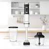 A white immersion blender with accessories on a table in a kitchen. Produktbild-Vorschau